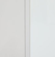 Nahaufnahme eines weißen Aufsatzschranks mit klaren Linien und minimalistischer Gestaltung, seitliche Perspektive.