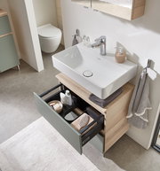 Moderner Waschbeckenunterschrank mit geöffneter Schublade, von oben fotografiert, zeigt stilvolle Aufbewahrungslösungen im Badezimmer.