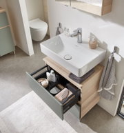 Moderner Waschbeckenunterschrank mit geöffneter Schublade, von oben fotografiert, zeigt stilvolle Aufbewahrungslösungen im Badezimmer.