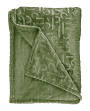 Grüne Decke mit eingeprägtem Muster, ausgebreitet und teilweise umgeschlagen, von oben betrachtet.