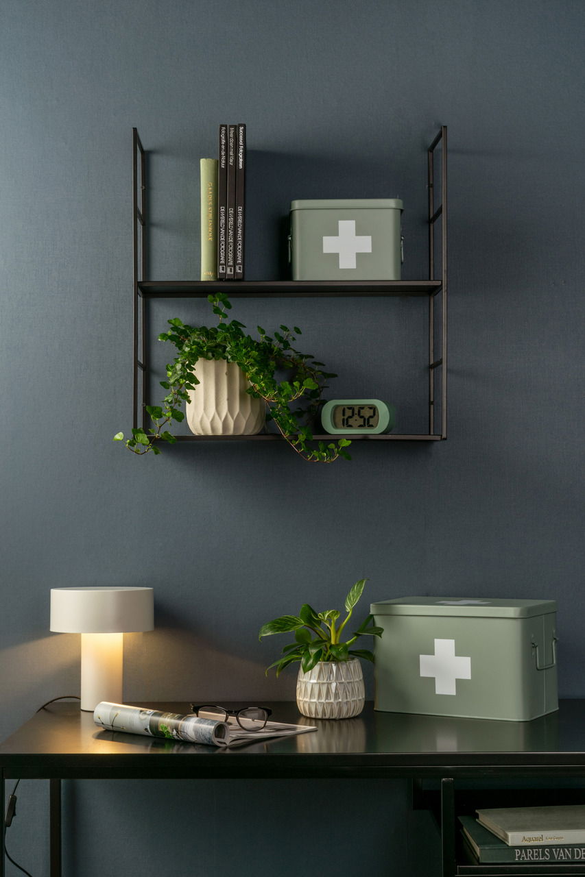 present time Aufbewahrungsbox MEDICINE Grüne Aufbewahrungsbox mit weißem Kreuz, auf einem Regal und Tisch platziert, aus seitlicher Perspektive fotografiert.