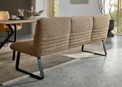 Achterkant van een moderne bank met bruine stoffen bekleding en zwarte metalen poten in een eetkamer.