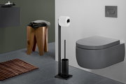 Modernes Badezimmer mit wandhängendem WC in Dunkelgrau, schwarzem freistehendem Toilettenpapierhalter mit Rollenhalter und WC-Bürste; Ansicht schräg von vorne rechts.