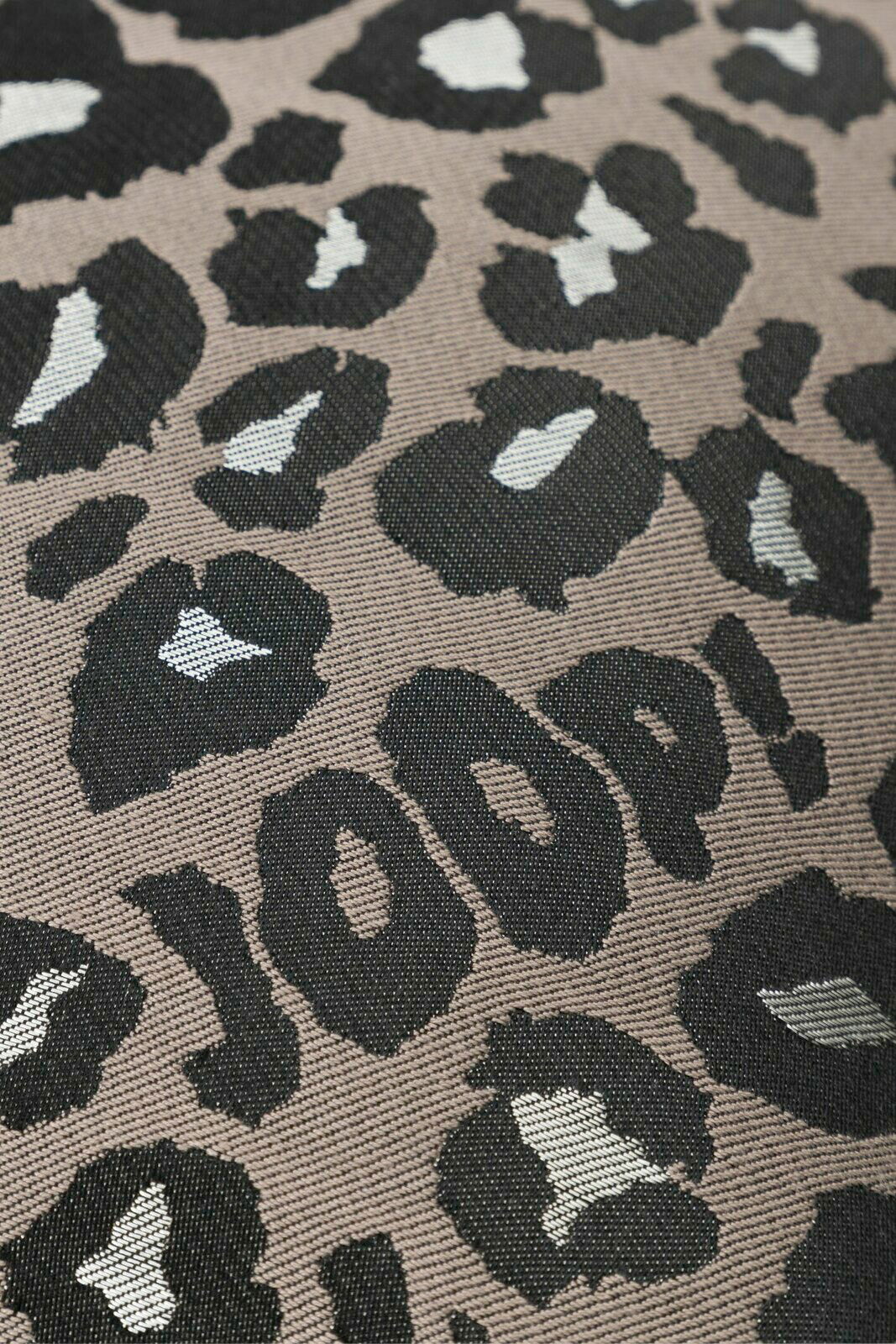 Nahaufnahme einer Zierkissenhülle mit Leopardenmuster und dem Schriftzug 'JOOP!' in Schwarz und Weiß auf grauem Hintergrund.