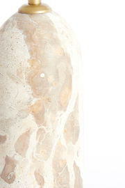 Nahaufnahme eines Lampenfußes aus hellem, gemustertem Stein mit goldener Halterung, seitliche Perspektive.