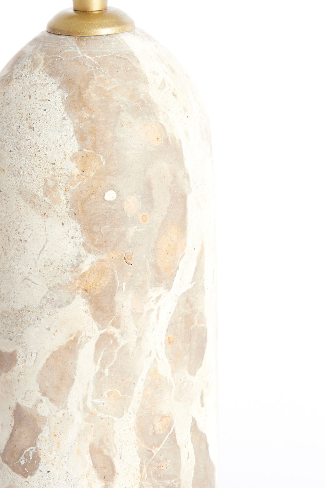 Nahaufnahme eines Lampenfußes aus hellem, gemustertem Stein mit goldener Halterung, seitliche Perspektive.