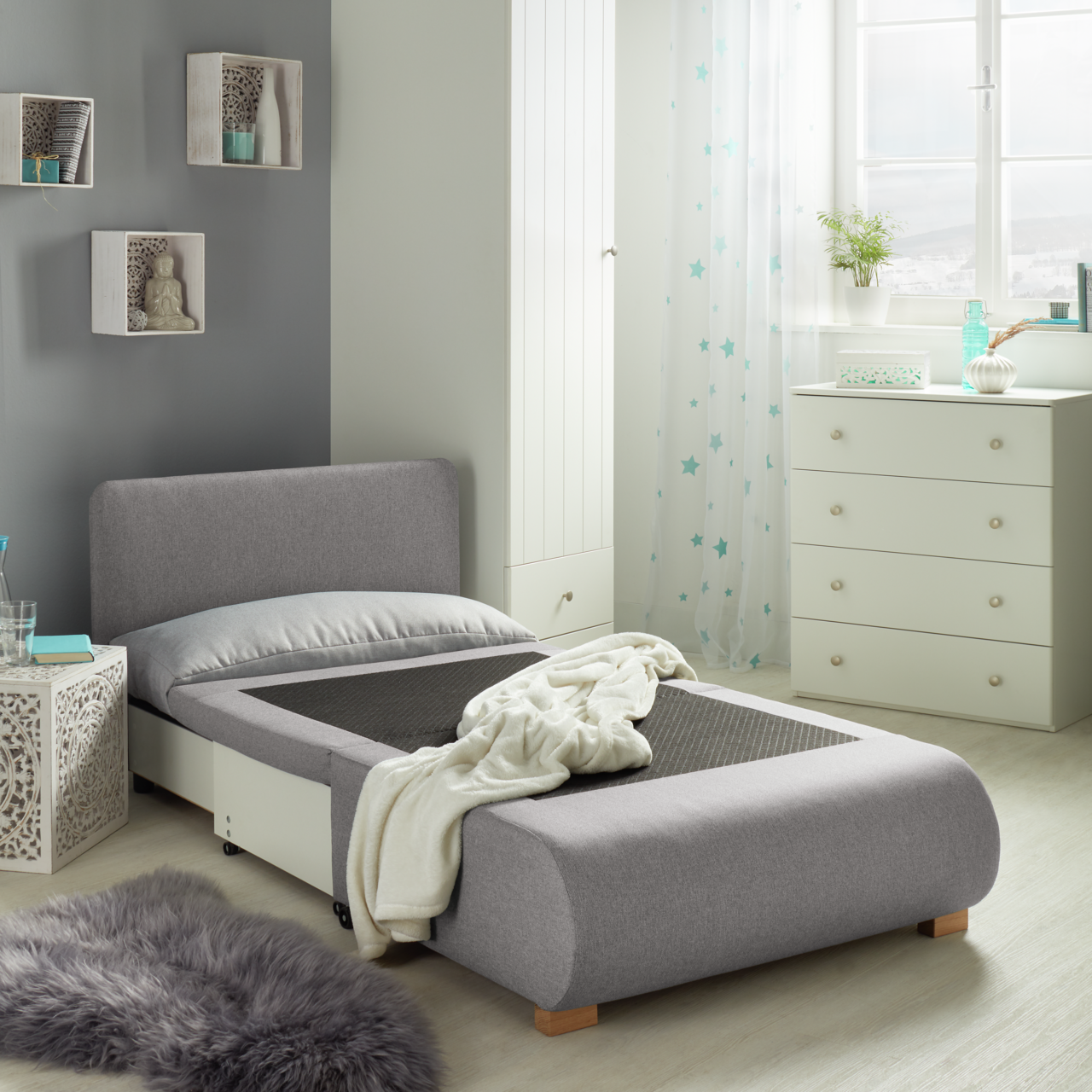 Z2 Schlafsessel KENY Grauer Funktionssessel in einem modernen Schlafzimmer, von der Seite betrachtet, mit ausgezogener Liegefläche und dekorativen Elementen im Hintergrund.