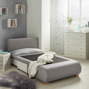 Grauer Funktionssessel in einem modernen Schlafzimmer, von der Seite betrachtet, mit ausgezogener Liegefläche und dekorativen Elementen im Hintergrund.