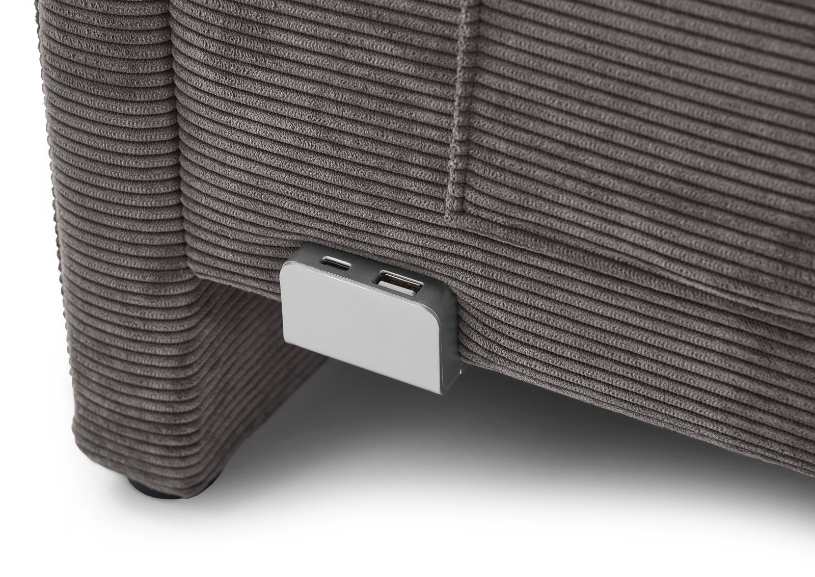 Nahaufnahme einer grauen Polsterliege mit USB-Anschluss an der Seite.