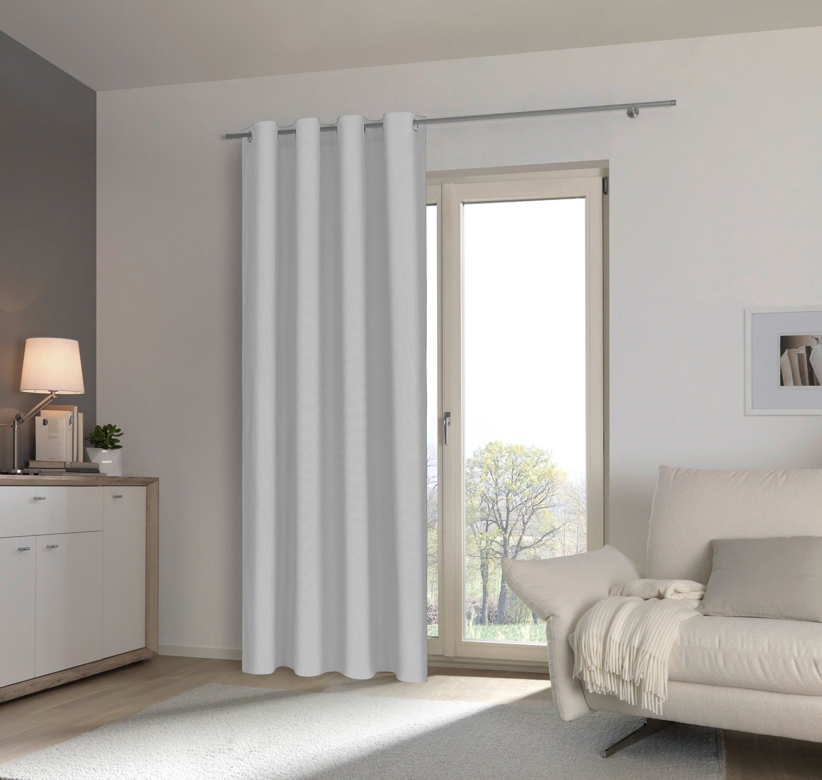 Esposa Ösenschal 135x245cm Moderner Wohnraum mit weißem Ösenschal vor einer Terrassentür, seitliche Perspektive