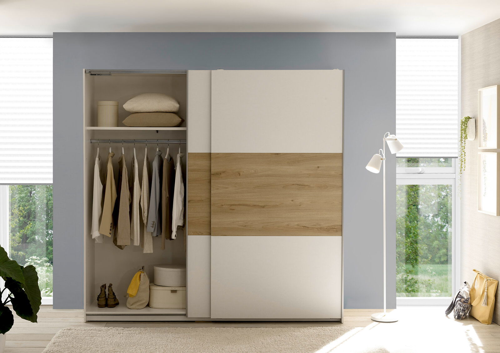 Moderner Kleiderschrank mit Schiebetüren in Holzoptik, teilweise geöffnet, mit Kleidung und Accessoires. Frontalansicht.