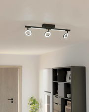 Moderne Deckenleuchte mit drei verstellbaren Spots in einem hellen Raum, seitliche Perspektive