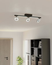 Moderne plafondlamp met drie verstelbare spots in een lichte ruimte, zijaanzicht