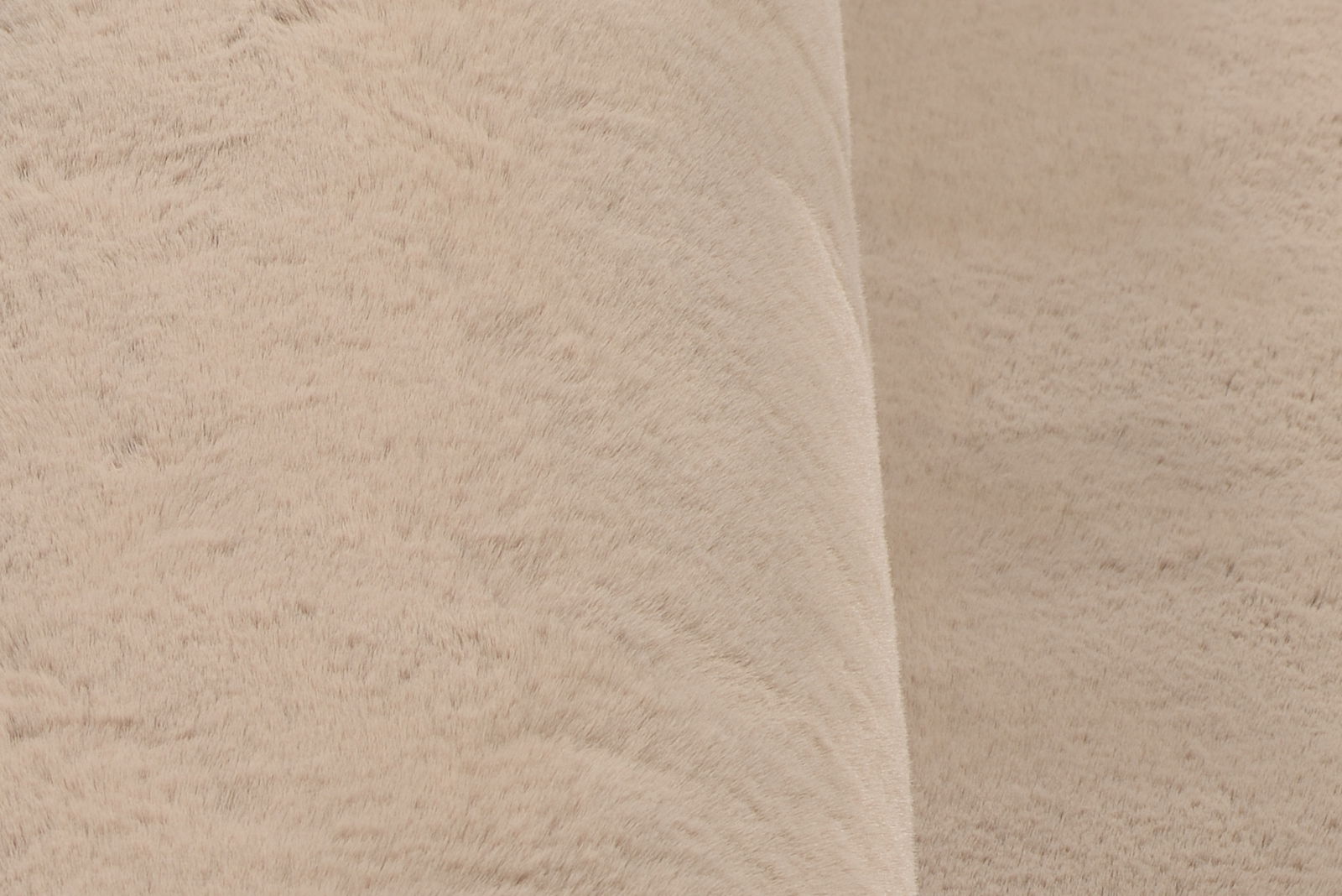 Nahaufnahme eines beigen Fellteppichs aus seitlicher Perspektive