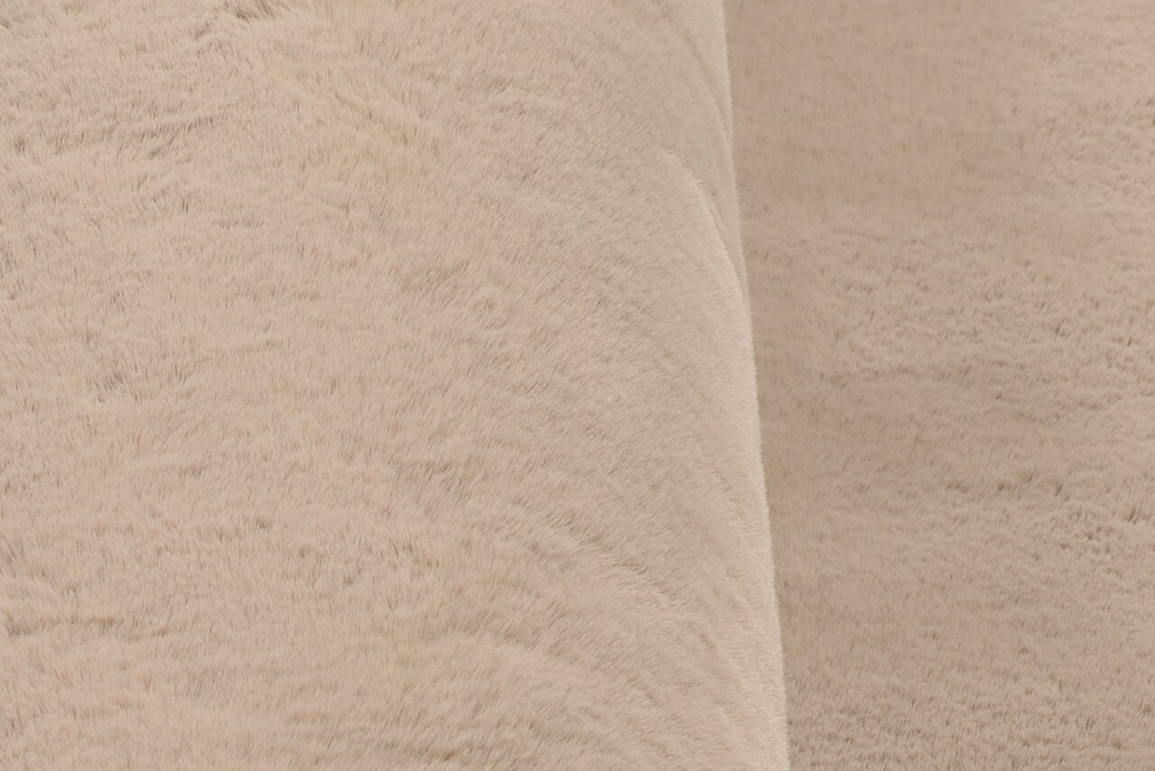 Nahaufnahme eines beigen Fellteppichs aus seitlicher Perspektive