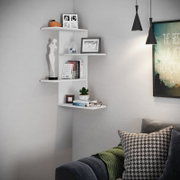 Modernes weißes Eck-Wandregal mit mehreren Ablageflächen, dekoriert mit Büchern, Bilderrahmen, Pflanze und Figur; perspektivische Ansicht schräg von vorne im Wohnraum.