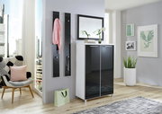 Moderner Eingangsbereich mit einem stilvollen Spiegel über einem weißen Schrank mit schwarzen Türen, dekoriert mit Pflanzen und Büchern, in einer hellen, urbanen Wohnung.