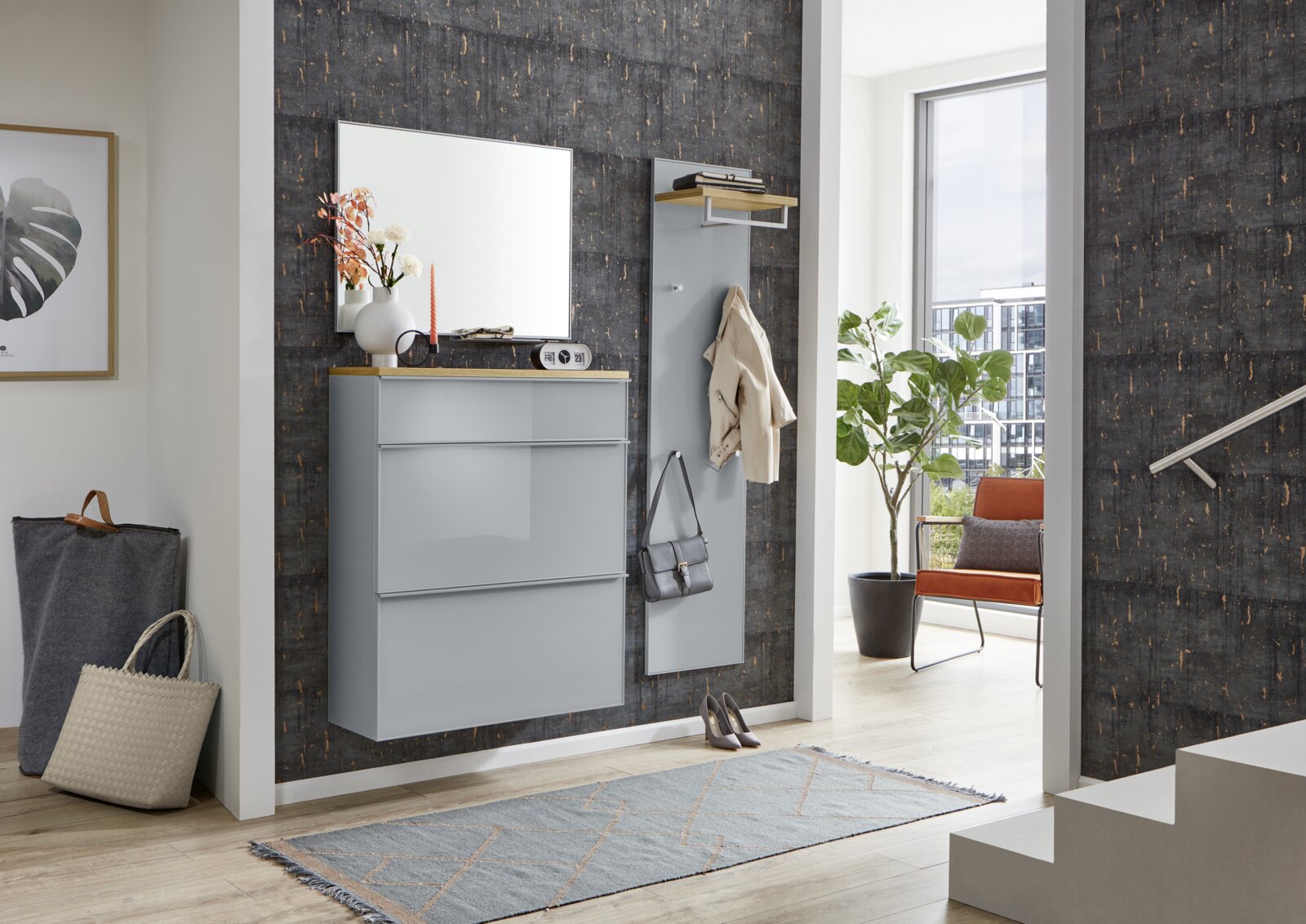 Modernes Flur-Set in Hellgrau mit hängendem Schuhschrank, Spiegel und Garderobenpaneel mit Ablage vor dunkler Akzentwand, frontal aus leicht seitlicher Perspektive aufgenommen