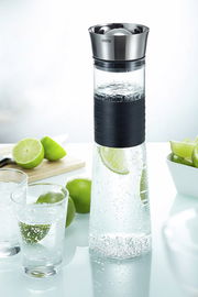 Karaffe 1l CASCADA mit Edelstahlverschluss und schwarzem Griff, gefüllt mit sprudelndem Wasser und Limettenscheiben, aus seitlicher Perspektive fotografiert.