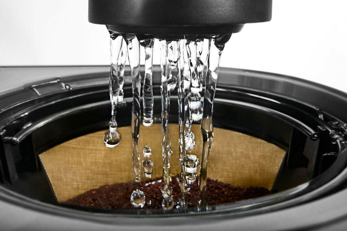 Nahaufnahme einer Kaffeemaschine in Onyx Schwarz, die Wasser über Kaffeepulver in einem Filter gießt.