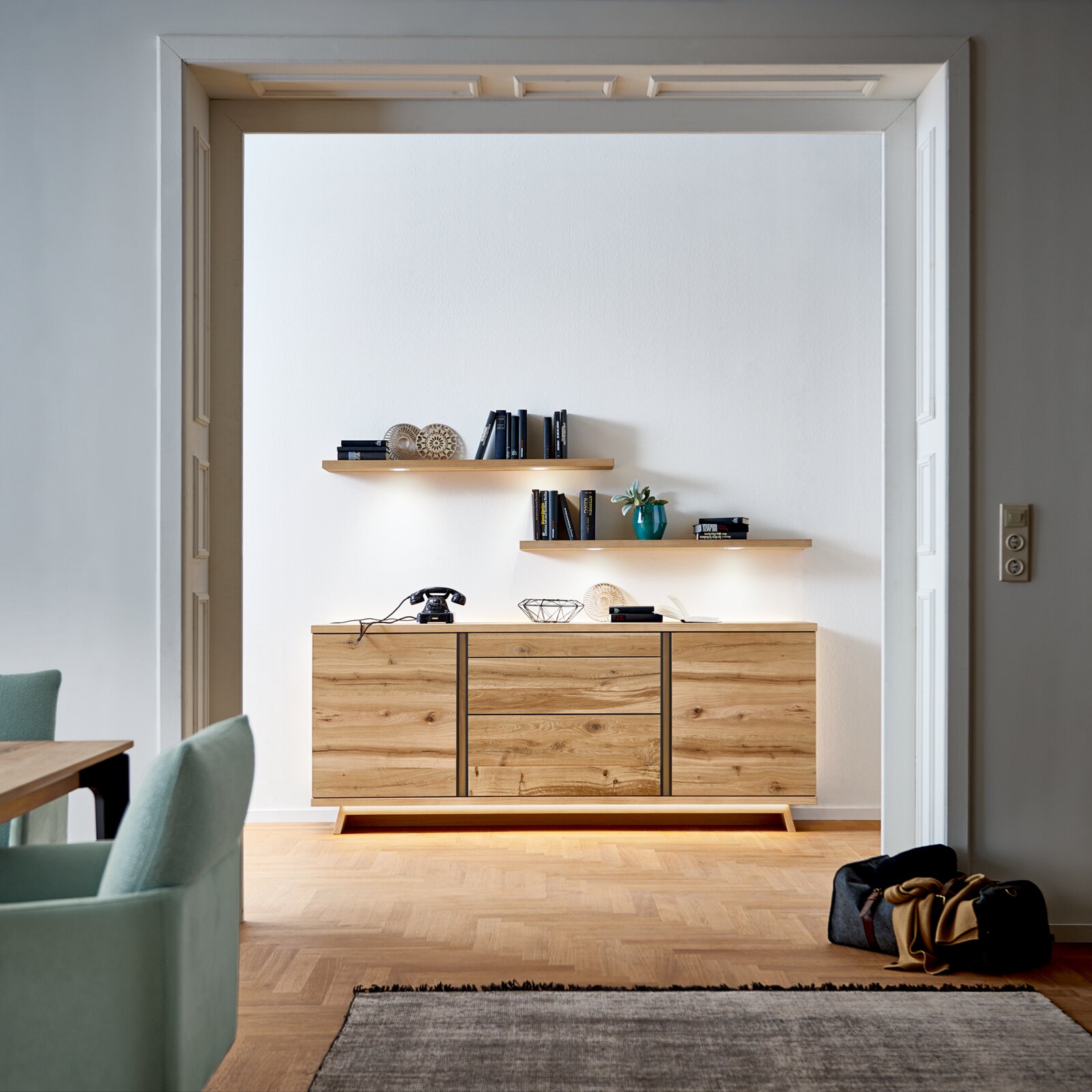 Houten dressoir in een moderne woonkamer, van voren gefotografeerd, met decoratieve planken erboven.