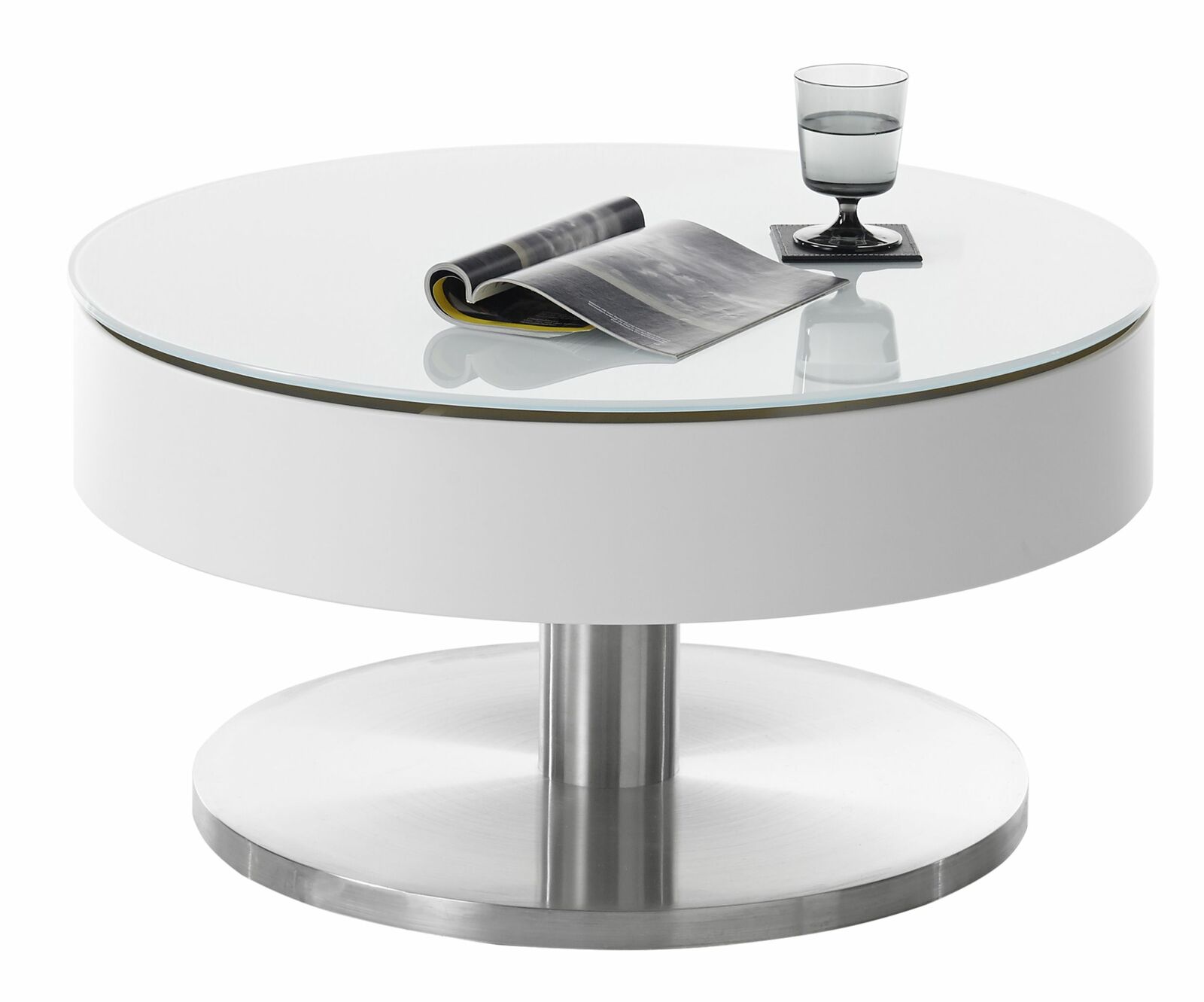 Moderner runder Couchtisch SUVA mit weißer Glasplatte und Edelstahlfuß, seitliche Perspektive, darauf ein Glas und eine Zeitschrift.