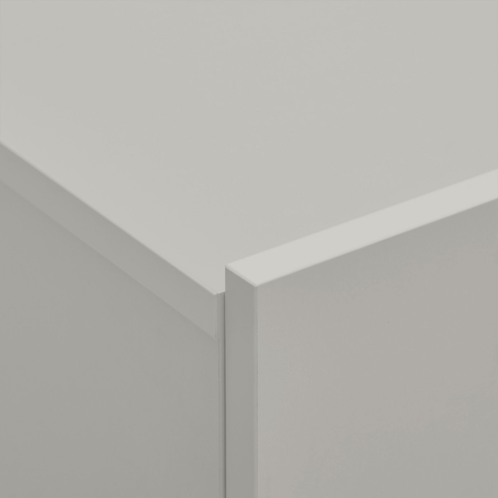 Nahaufnahme einer Ecke eines weißen Hängeschuhschranks aus der Vogelperspektive