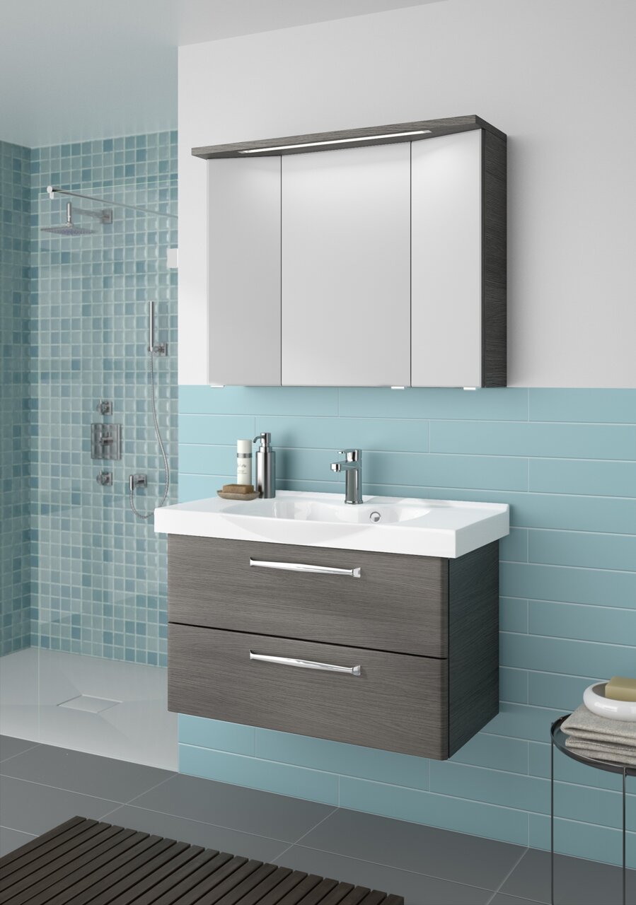 Pelipal Badblock 92cm TRENTINO Moderner Badblock mit grauen Schubladen und weißem Waschbecken, frontal betrachtet, vor einer Wand mit blauen Fliesen.