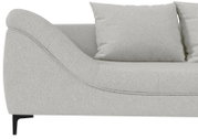 Detailansicht eines hellgrauen Stoffsofas mit abgerundeter Armlehne, Sitzfläche und Rückenkissen, seitliche Perspektive