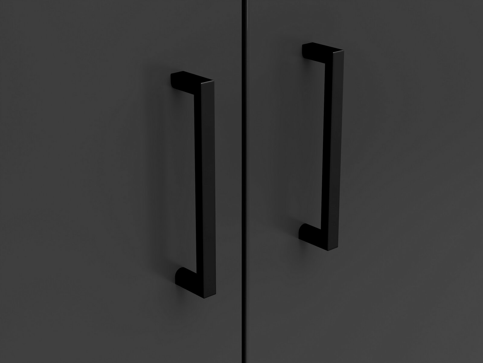 Nahaufnahme von zwei schwarzen Griffen auf einer dunklen Kommodenoberfläche, frontal betrachtet.