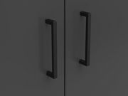 Nahaufnahme von zwei schwarzen Griffen auf einer dunklen Kommodenoberfläche, frontal betrachtet.