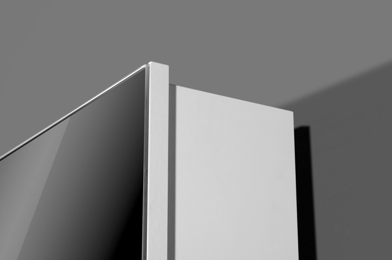 Nahaufnahme der oberen Ecke eines modernen Drehschuhschranks in minimalistischem Design, seitliche Perspektive