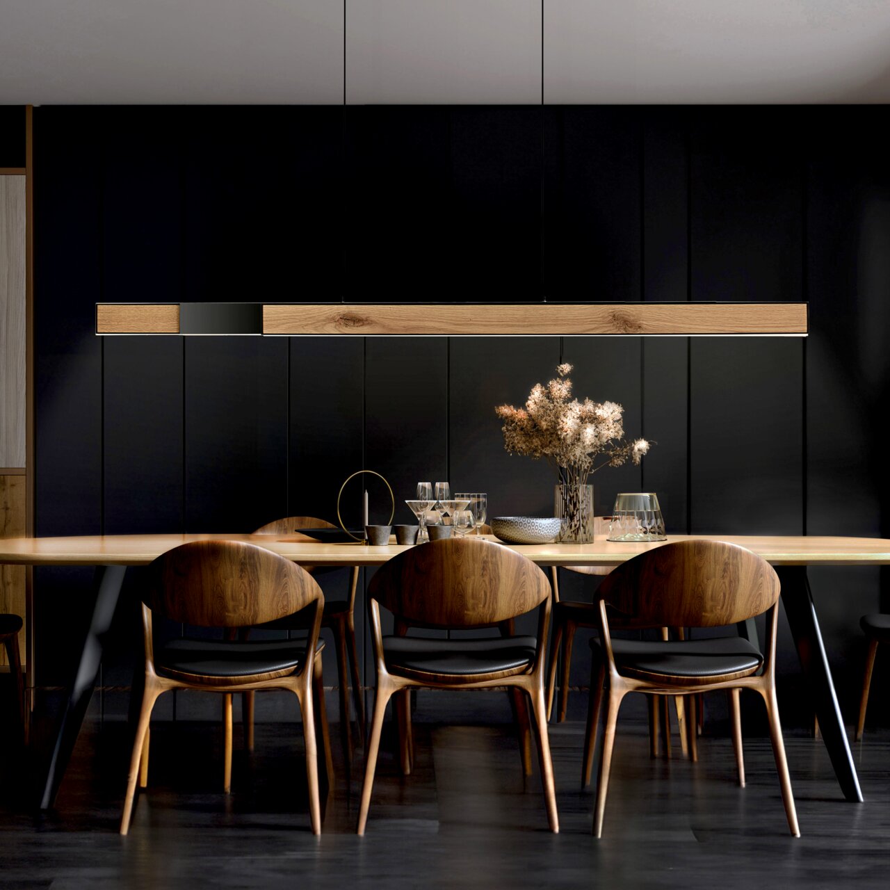 Moderne Pendelleuchte PURE-MOTO-RISE über einem Esstisch, aus Holz und Metall, in einem stilvollen Esszimmer mit dunklen Wänden, seitliche Perspektive.