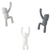 Drei Wandhaken in Form von kletternden Figuren in verschiedenen Farben, aus der Frontalperspektive betrachtet.