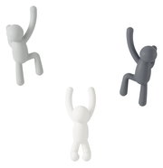 Drei Wandhaken in Form von kletternden Figuren in verschiedenen Farben, aus der Frontalperspektive betrachtet.