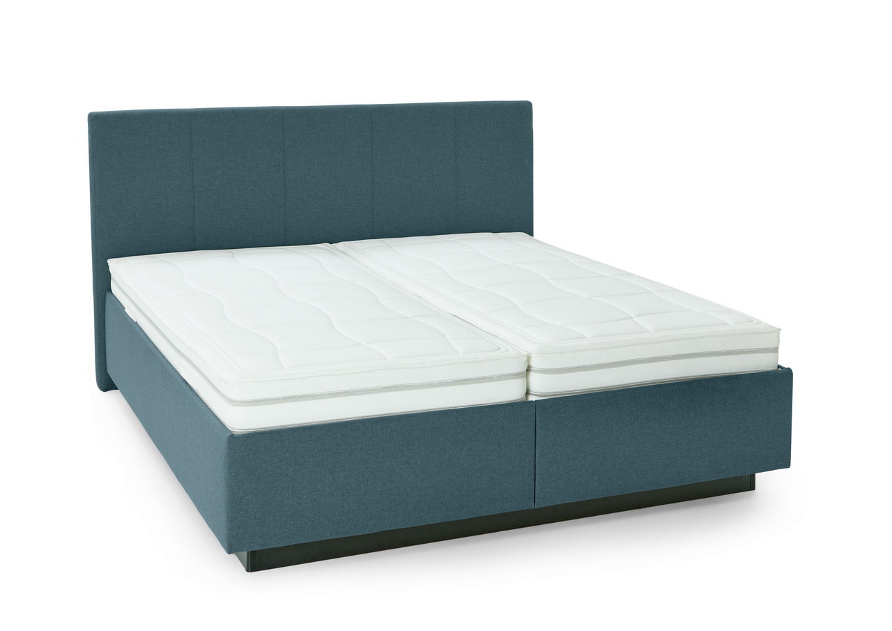 Polsterbett in blauer Farbe mit hohem Kopfteil und zwei weißen Matratzen, seitliche Perspektive