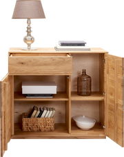 Holz-Sideboard mit geöffneter Schublade und Türen, dekoriert mit einer Lampe und Büchern, aus der Frontalperspektive.