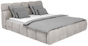 Polsterbettgestell in hellgrauem Stoff mit mehreren Kissen und Decke, seitliche Perspektive
