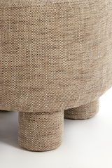 Nahaufnahme eines Sessels mit beigem, strukturiertem Stoffbezug und runden Beinen, seitliche Perspektive