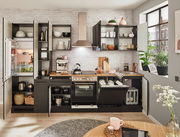 Moderne Küchenzeile in dunklem Design mit offenen Schränken, Kühlschrank, Herd und Spüle, fotografiert aus frontaler Perspektive.