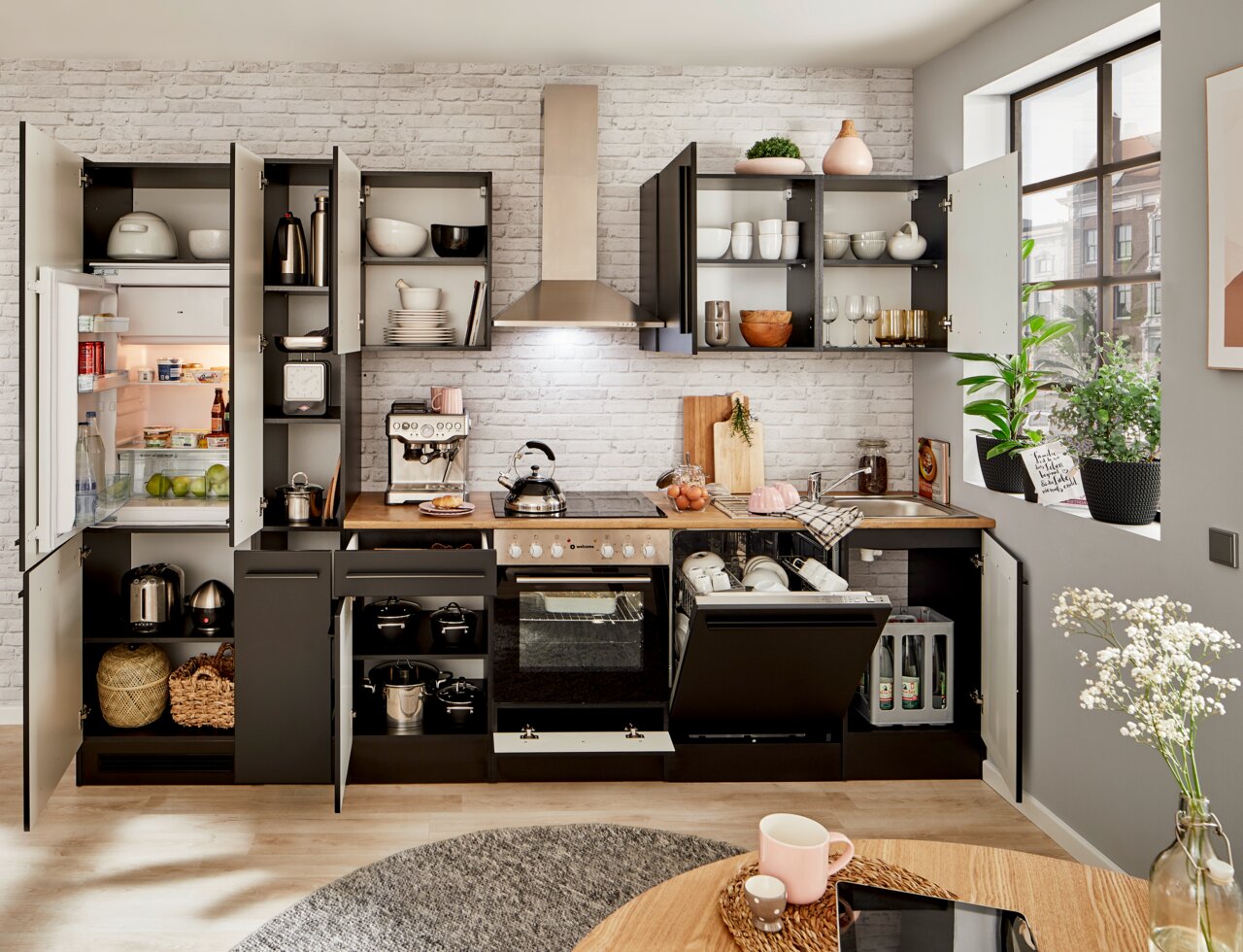 Moderne Küchenzeile in dunklem Design mit offenen Schränken, Kühlschrank, Herd und Spüle, fotografiert aus frontaler Perspektive.