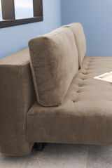 Nahaufnahme eines braunen Funktionssofas mit geripptem Stoffbezug, seitliche Perspektive.