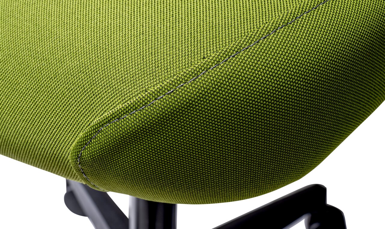 Close-up van een groene draaistoel met stoffen bekleding, zijaanzicht