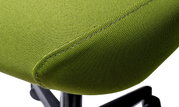 Close-up van een groene draaistoel met stoffen bekleding, zijaanzicht