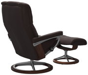 Rückansicht eines braunen Einzelsessels mit passendem Hocker, beide mit modernem Metall- und Holzgestell.