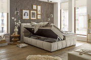 Boxspringbett VALENCIA mit Stauraum, seitliche Perspektive, in modernem Schlafzimmer mit dekorativer Wand und großen Fenstern.