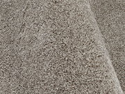 Nahaufnahme eines Uni-Teppichs in beige mit weicher, flauschiger Textur, seitliche Perspektive