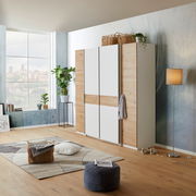 Moderner Dreh-Schwebetürenschrank mit vier Türen in einem stilvollen Raum, seitliche Perspektive.