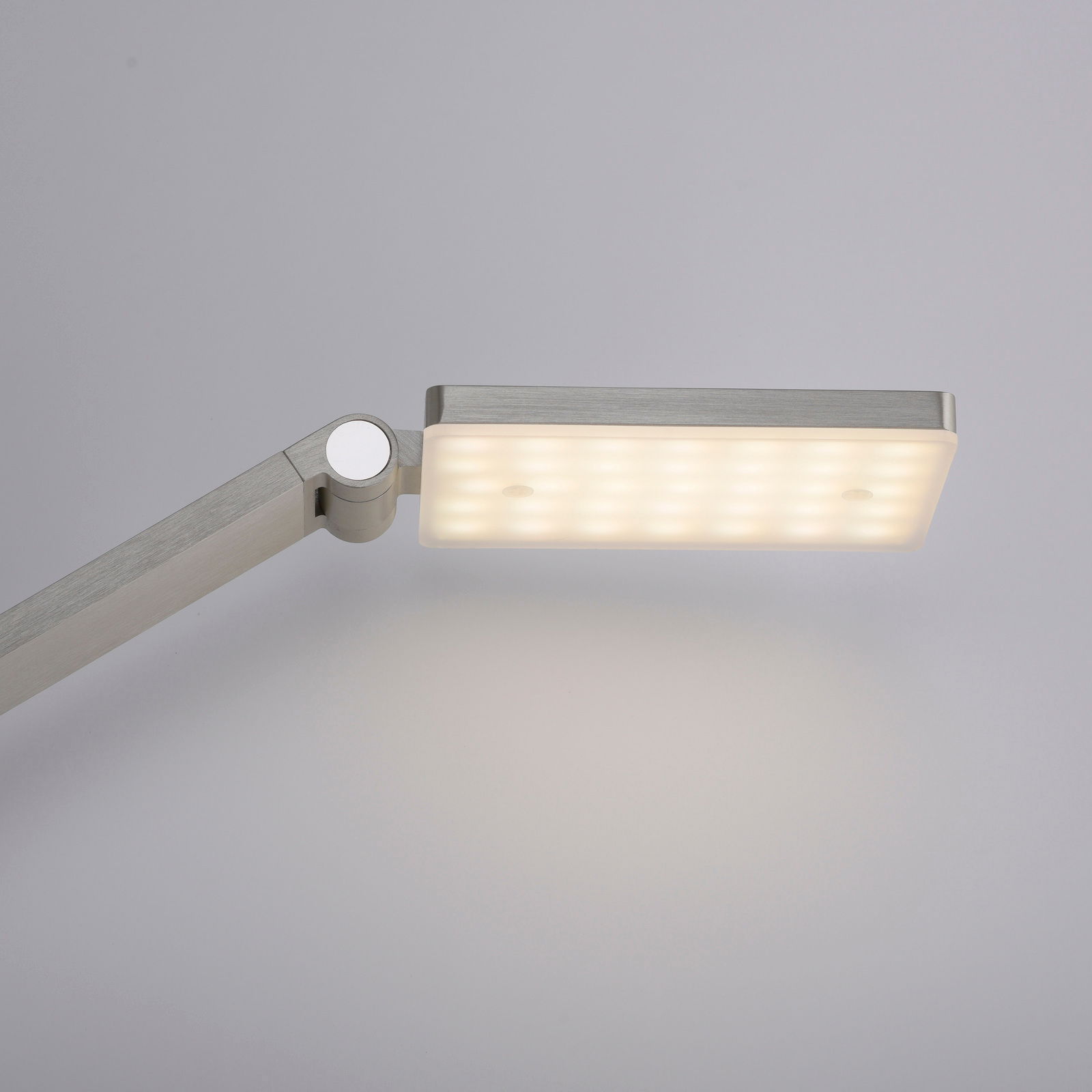 Nahaufnahme einer modernen LED-Stehleuchte mit rechteckigem, leuchtendem Kopf und verstellbarem Arm in seitlicher Perspektive.