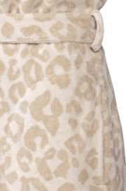 Close-up van een badjas met een beige luipaardprint, gezien vanaf de zijkant